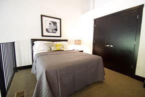 Council Bluffs apartment for rent - A bedroom with a bed, a picture frame, and a wardrobe.