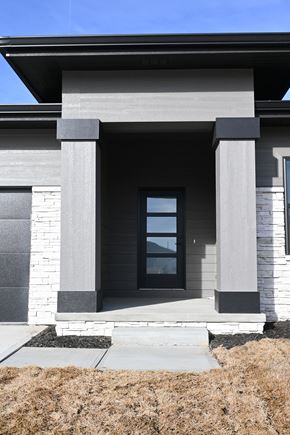 Papillion apartment for rent - A modern house with a grey front and a glass door.