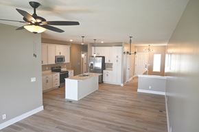 Omaha townhouse for rent - A kitchen with a fan on the ceiling and wooden floors.