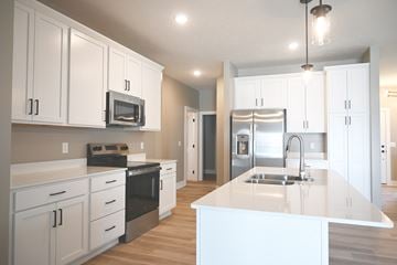Omaha townhouse for rent - A kitchen with white cabinets and a white island.