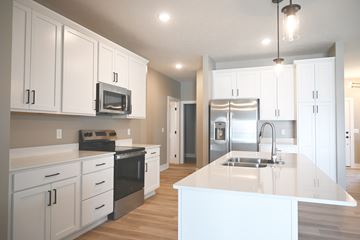 Omaha townhouse for rent - A kitchen with white cabinets and a white island.