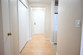 Omaha apartment for rent - A hallway with a wooden floor and white walls.