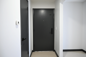 Omaha apartment for rent - A black door with a handle and a lock is in a white room.