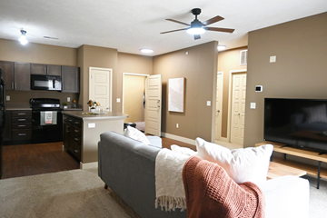 Grand Island apartment for rent - A living room with a grey couch and a ceiling fan.