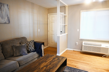 Omaha apartment for rent - A living room with a grey couch and a wooden coffee table.