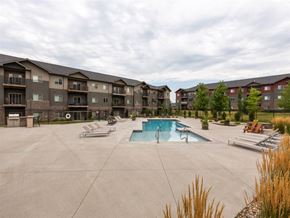 Gretna apartment for rent - A swimming pool surrounded by lounge chairs and apartment buildings.