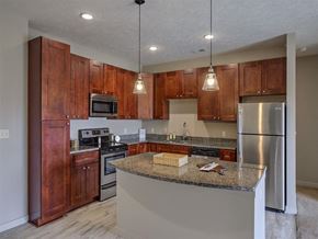 Gretna apartment for rent - A kitchen with wooden cabinets and a granite countertop.