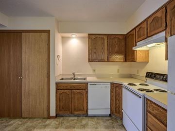 Gretna apartment for rent - A kitchen with wooden cabinets and white appliances.