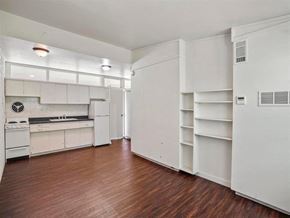 Kearney apartment for rent - A kitchen with white cabinets and a wooden floor.