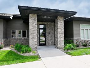 Kearney apartment for rent - The clubhouse has a glass door and is made of brick.