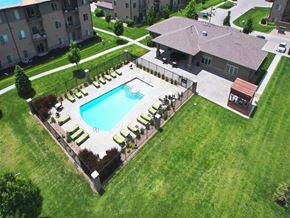Kearney apartment for rent - A swimming pool surrounded by a concrete border and lounge chairs.