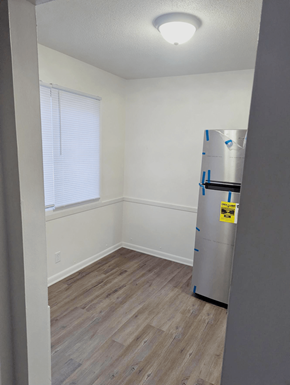 Omaha apartment for rent - Dining area with wood style flooring and a window near the kitchen at Northbrook Apartments