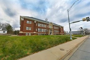 Omaha apartment for rent - A red brick building with a white roof and a white trim around the windows.