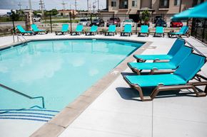 Grand Island apartment for rent - A pool with blue chairs and a white fence.