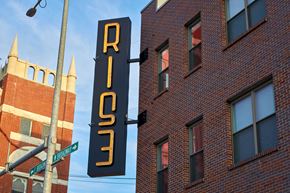 Council Bluffs apartment for rent - A sign for RISE is hanging next to a street sign.