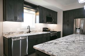 Omaha apartment for rent - A kitchen with black cabinets and granite countertops.