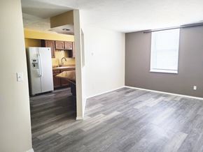 Grand Island apartment for rent - A kitchen with a refrigerator and cabinets is visible through an open doorway.