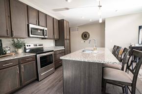 Alliance apartment for rent - A kitchen with brown cabinets and a granite countertop.