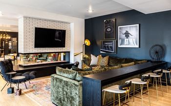 A living room with a large couch and a television on the wall.