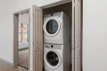A stack of two washing machines in a cabinet.