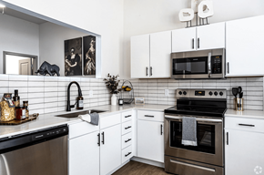 Kansas City apartment for rent - A modern kitchen with white cabinets and a black stove top.at Converge KC Uptown, Kansas City, 64111