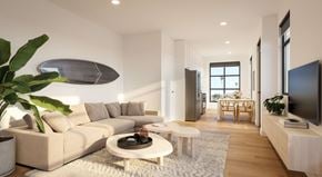 Ventura apartment for rent - A modern living room with a large couch, a coffee table, and a flat-screen TV.