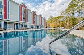 Huntsville apartment for rent - the preserve at ballantyne commons pool area with apartment buildings and trees