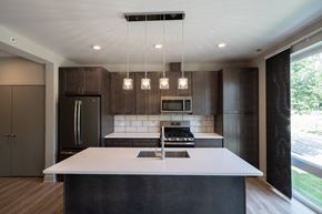 Downers Grove apartment for rent - A modern kitchen with a large island and dark brown cabinets.