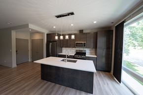 Downers Grove apartment for rent - A modern kitchen with a large island and dark wood cabinets.