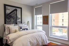 Chicago apartment for rent - a bedroom with a bed and two windows and a painting on the wall
