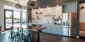 Barrington apartment for rent - a kitchen with a bar and a stainless steel refrigerator at Barrington 101, Barrington, IL