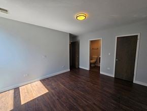 Chicago apartment for rent - a living room with wood floors and a door to a bathroom