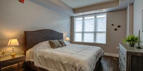 Barrington apartment for rent - a bedroom with a large bed and a window at Barrington 101, Barrington, IL