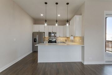 Chicago apartment for rent - a kitchen with white cabinets and a counter top and a refrigerator