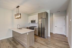 Highwood apartment for rent - a kitchen with a large island and stainless steel refrigerator