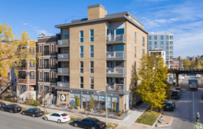 Chicago apartment for rent - A street view of a residential area with cars parked on the side of the road and apartment buildings in the background.