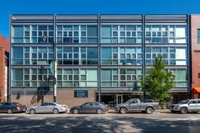 Chicago apartment for rent - A modern building with a parking lot in front of it.