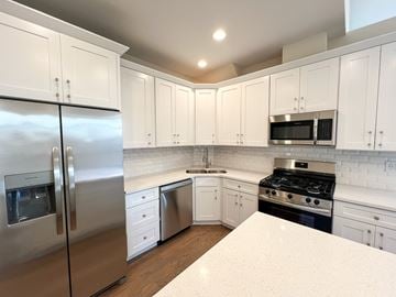 Chicago apartment for rent - A kitchen with white cabinets and a stainless steel refrigerator.