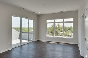 Highwood apartment for rent - an empty living room with large windows and a balcony