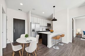 Chicago apartment for rent - Spacious kitchen at Highpoint Buena Park on Broadway with quartz countertops, stainless steel appliances, and a breakfast bar overlooking an open-concept dining area in a luxury Buena Park apartment near Lake Michigan