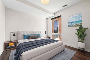 Chicago apartment for rent - A bedroom with a large bed and a painting on the wall.
