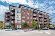 Highwood apartment for rent - A large apartment building with balconies and a street in front.