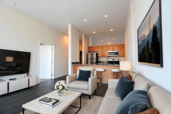 Chicago apartment for rent - a living room and kitchen with a couch and a table