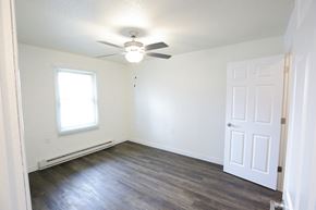Monroeville apartment for rent - A room with a ceiling fan and a door.