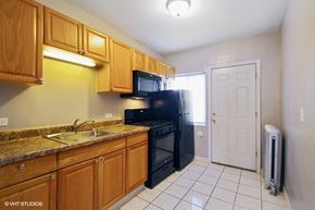 Chicago apartment for rent - Bright kitchen with black appliances