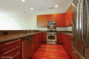 Chicago apartment for rent - a kitchen with wooden cabinets and stainless steel appliances