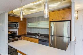 Denver apartment for rent - Kitchen with stainless steel appliances and a breakfast bar at Metropolis in Denver, CO