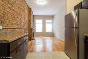 Chicago apartment for rent - A kitchen with a refrigerator and a brick wall.