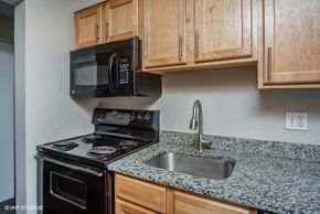 Denver apartment for rent - Kitchen with black appliances and a built-in microwave at 1190 S Bellaire St in Denver, CO