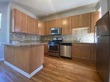 Chicago apartment for rent - a kitchen with wooden cabinets and stainless steel appliances